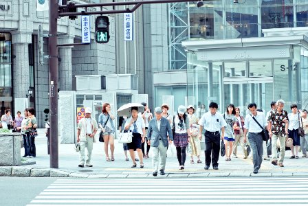 people crossing pedestrian lane near building at daytime photo