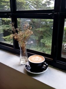 black ceramic coffee mug on window photo