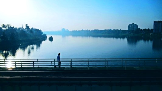 person walking on bridge near body of water photo