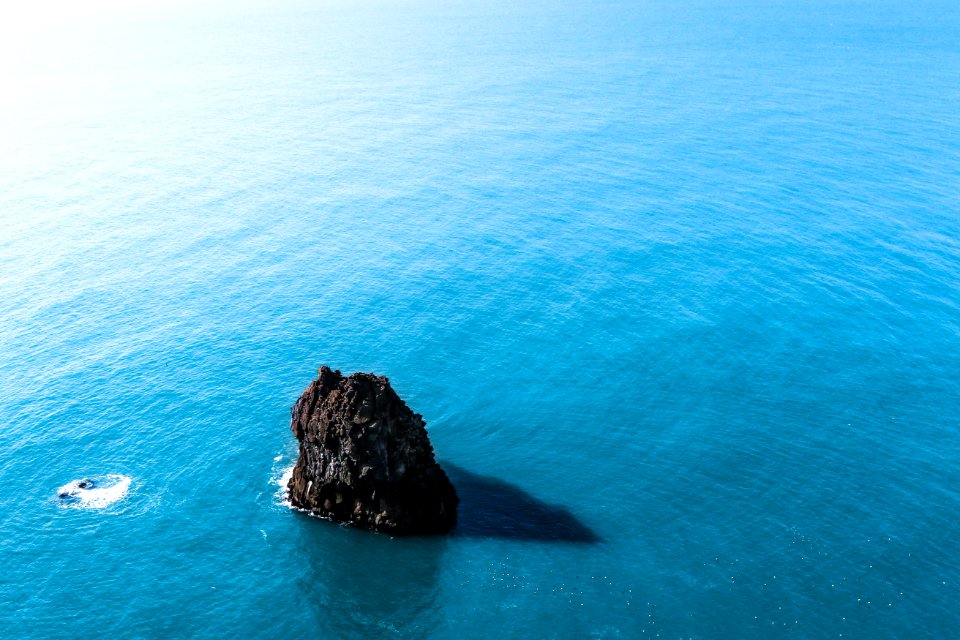 brown rock formation on body of water