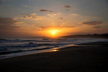 sea waves crashing on shore during sunset