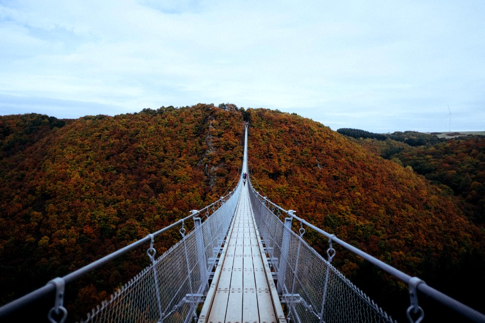 person walking on white hanging bridge during daytime