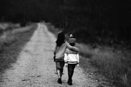 grayscale photography of kids walking on road photo