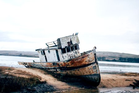 wrecked white and brown ship on sand