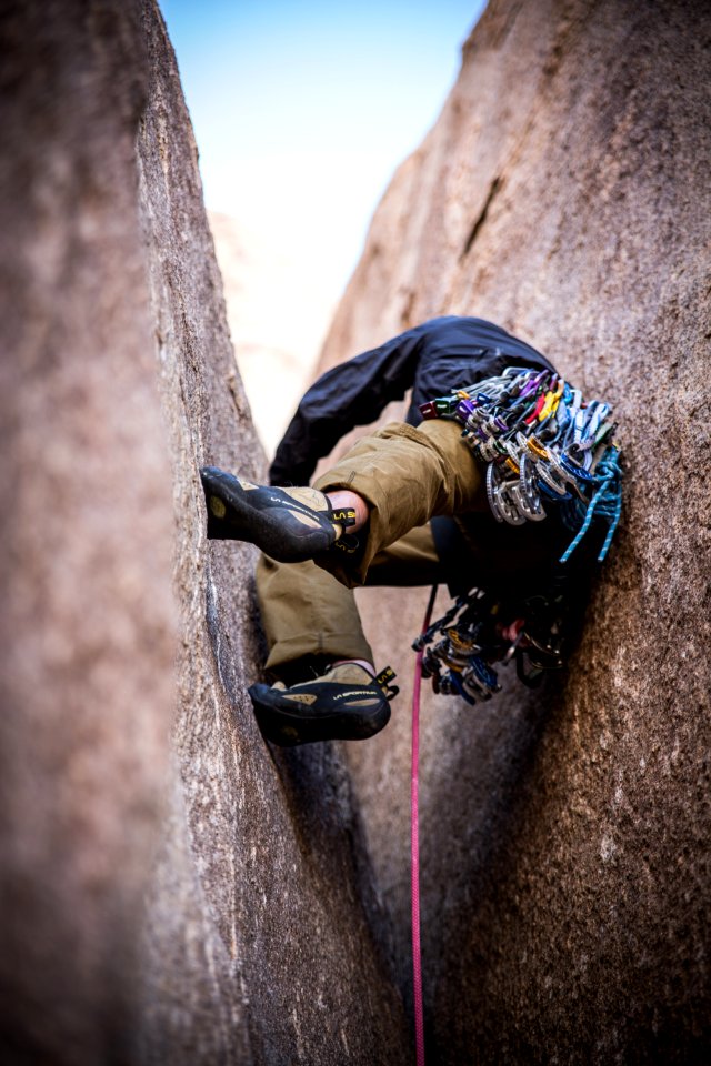 person climbing between cliff during daytime