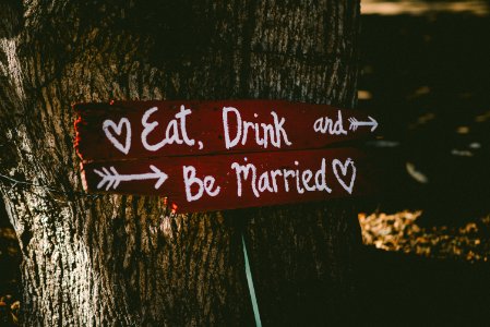 red and white eat, drink, and be married signage near brown tree photo