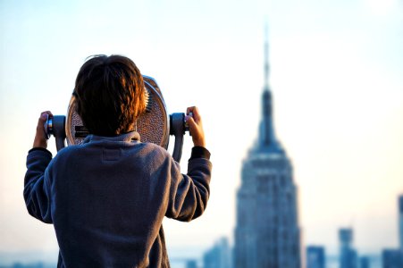 child looking at Empire State building through tower viewer photo