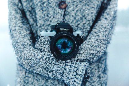 person holding black and gray Nikon DSLR camera photo