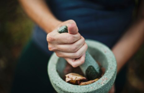 person grinding on mortar and pestle photo