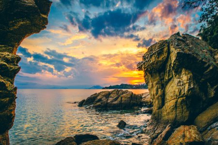 seashore near rocky mountain during golden hour photo