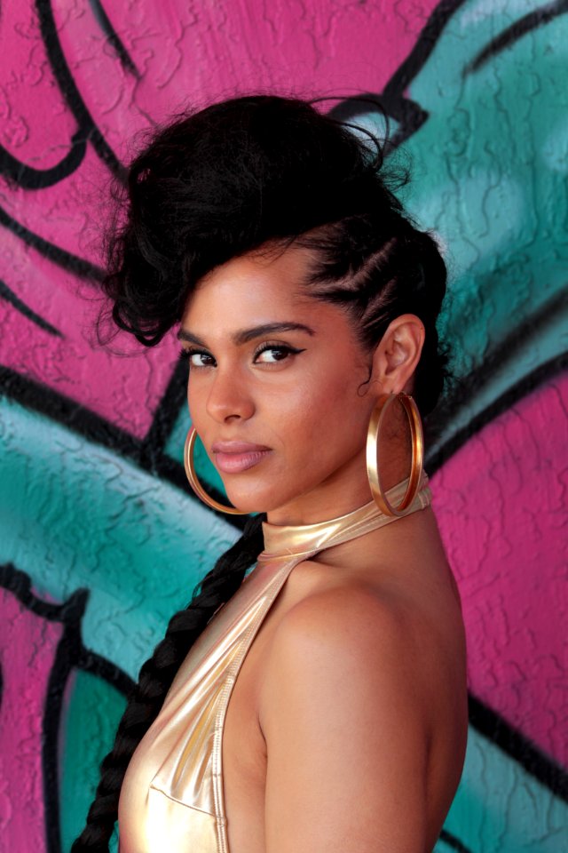 Alicia Keys standing near wall with graffiti art