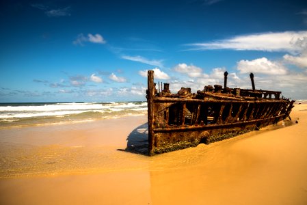 brown shipwreck on coast during daytime