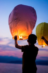 person holding yellow flammable balloon