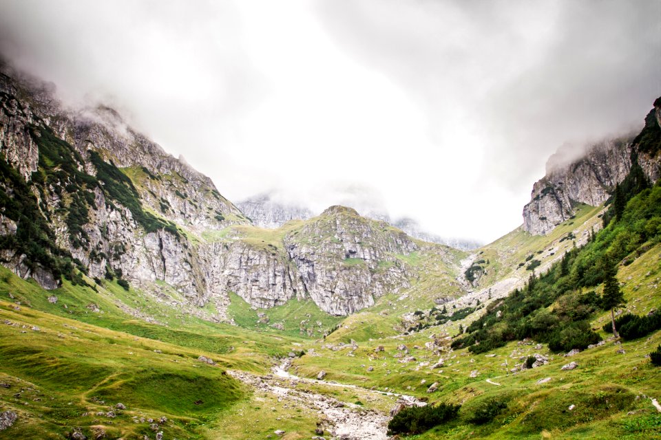 green grass surrounded with mountains