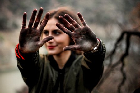 woman showing her hands with black paint