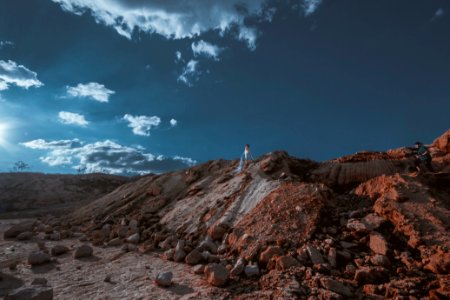person standing on tops of rock formation during daytime photo