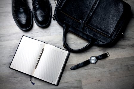white notebook near black bag photo