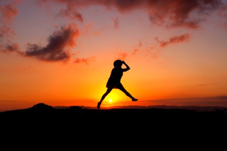 silhouette of human jumping during sunset