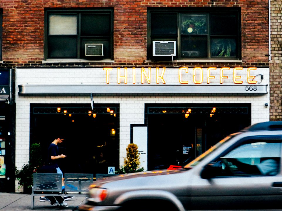 gray car at the front of Think Coffee shop
