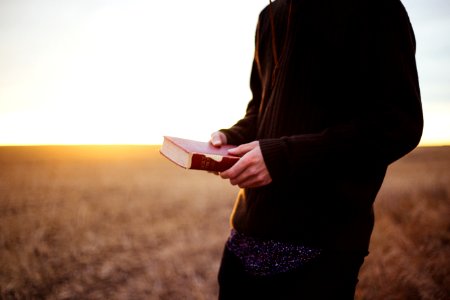 man holding book in the ricefield photo