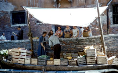 man and woman on boat selling fruits in crate photo