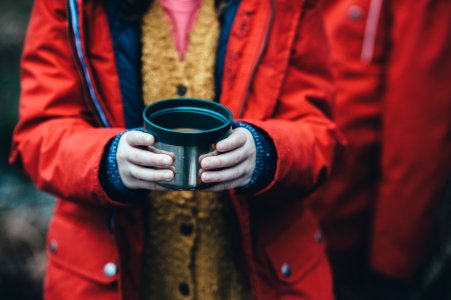 shallow focus photography of person holding green plastic container photo