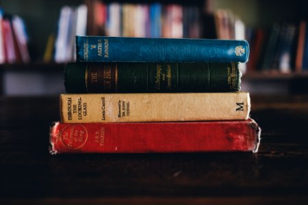 four assorted reading books on brown surface photo