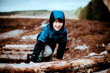 boy climbing on tree stump photo