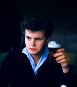 man sitting while holding glass of beer photo