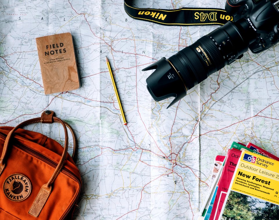 flat lay photography of camera, book, and bag