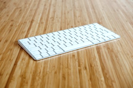 silver and white keyboard on brown wooden surface photo