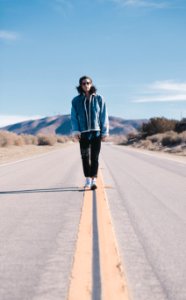 man walking in the middle on road at daylight photo