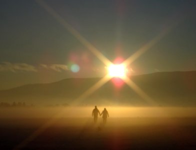 man and woman holding hands walking through the mountain photo