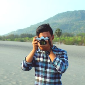 man holding gray and black camera during daytime photo