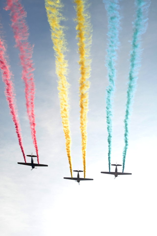 photograph of three plain releasing colorful smokes