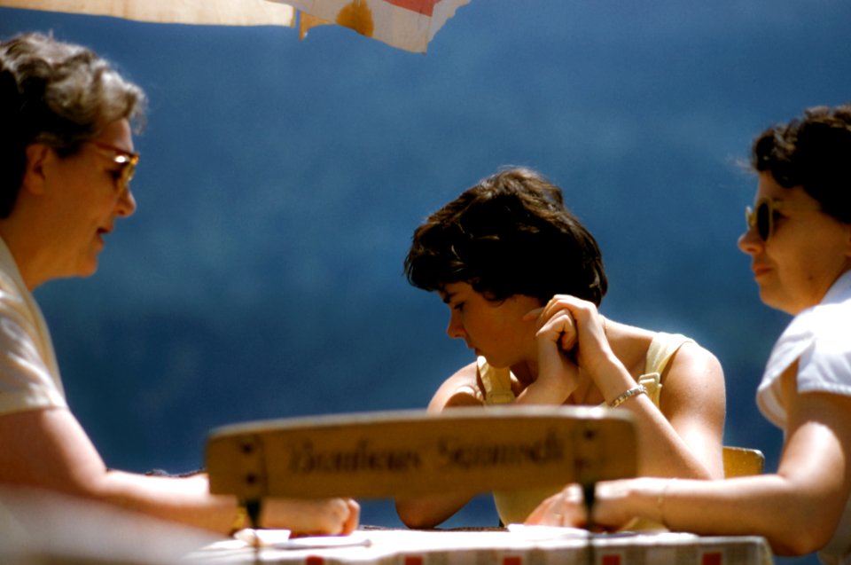 three person sitting beside table