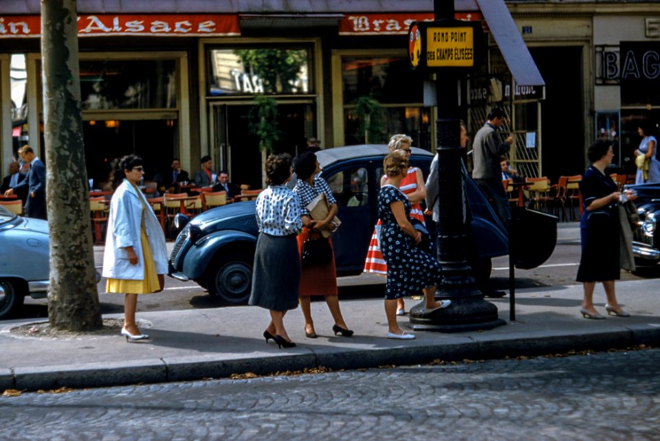 female women standing near black pole