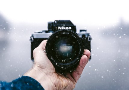person holding Nikon DSLR camera photo