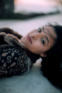 selective focus photo of woman lying on ground smiling photo