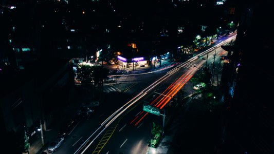 timelapse photography of vehicle passing on road at nighttime photo