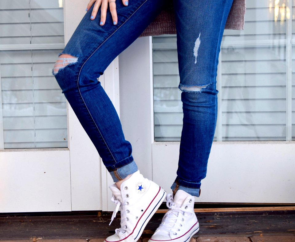 women's distressed blue denim jeans and pair of white Converse Allstar high-tops
