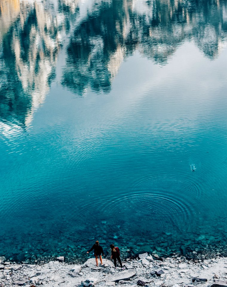 aerial view photography of two people standing on shore