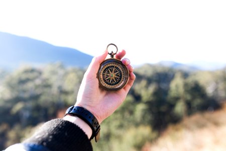 person holding compass selective focus photography photo