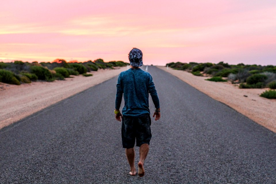 man walking on gray concrete road