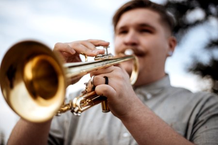 man playing trumpet outdoors photo