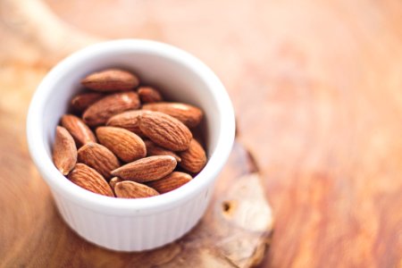 shallow focus photography of almonds in white ceramic bowl photo