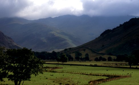 cloudy sky over mountains and grass field photo