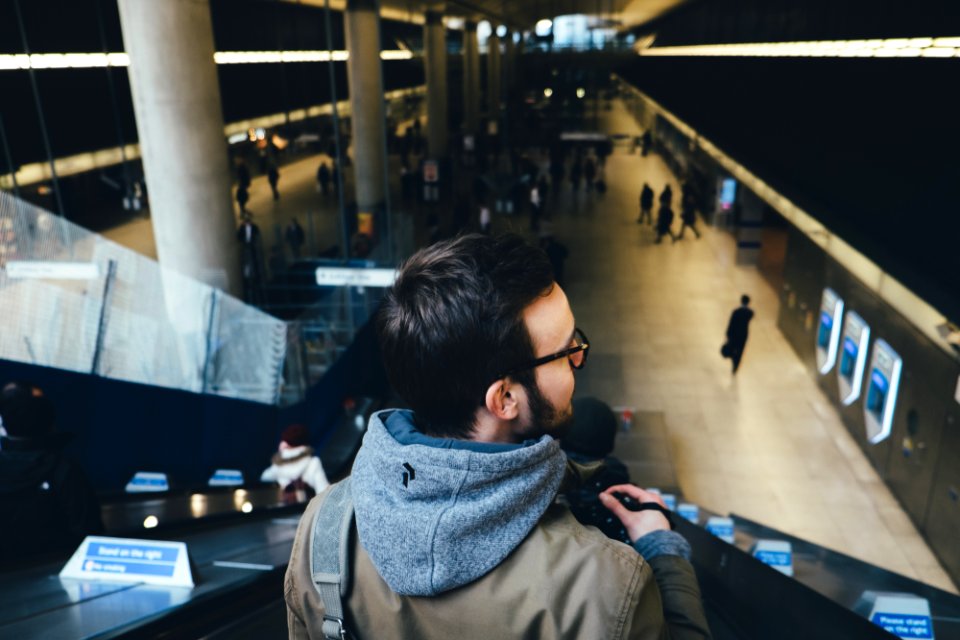 person standing on escalator in subway station photo