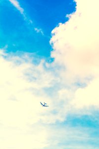 low angle photo of airplane and white clouds during daytime photo