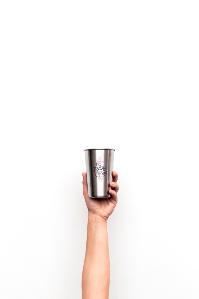 person holding gray stainless steel drinking cup